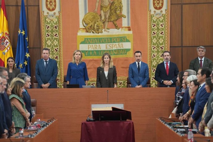 Los diputados del Parlamento andaluz guardan un minuto de silencio en el Pleno.