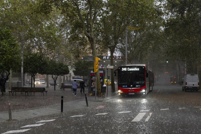 Archivo - Varias personas esperan en la parada del bus, a 30 de octubre de 2024, en Barcelona, Catalunya (España). El Servei Meteorològic de Catalunya (SMC) ha activado la alerta roja por tiempo violento y granizadas en el territorio catalán. Han alertado