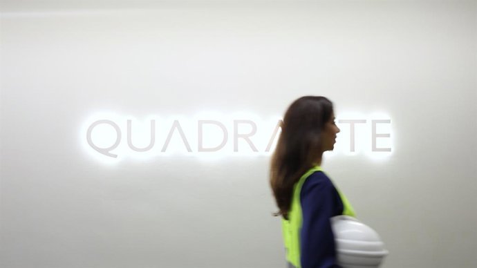 Archivo - Trabajadora de Quadrante pasando por delante del logo de la compañía portuguesa de ingeniería.
