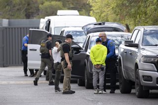 September 15, 2026, Phoenix, Arizona, USA: Agents with Immigration and Customs Enforcement transfer individuals arrested earlier in the morning to a private contractor for transport.