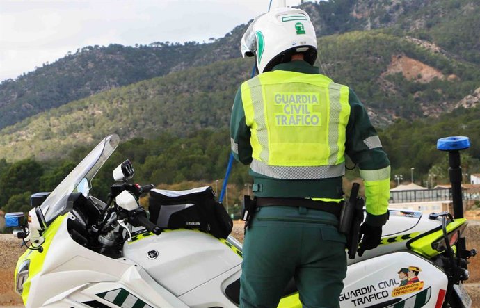 Archivo - Arquivo - Um agente da Guarda Civil de Trânsito, de costas, em uma estrada ao lado de sua motocicleta, com uma montanha ao fundo.