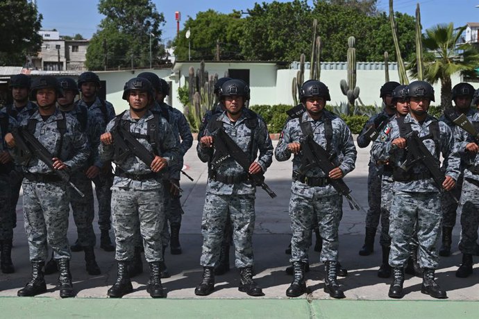 Archivo - Arquivo - 17 de março de 2026, Tijuana, Baixa Califórnia, México: Oficiais da Guarda Nacional Mexicana permanecem em formação durante uma cerimônia de destruição na qual foram exibidas 500 armas, das 1.700 apreendidas de organizações criminosas,