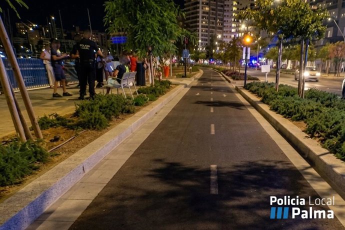Agentes de la Policía Local de Palma junto a un grupo de jóvenes en el paseo marítimo de Palma.