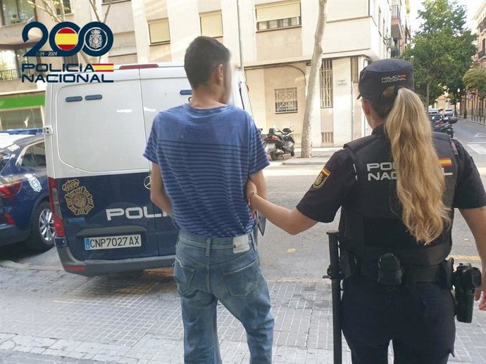 Una agente de la Policía Nacional detiene al presunto autor de los robos en balnearios de Playa de Palma.