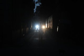 Archivo - Una persona camina por las calles de La Habana en pleno apagón de la isla de Cuba