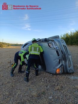 Efectivos de bomberos junto al coche siniestrado.