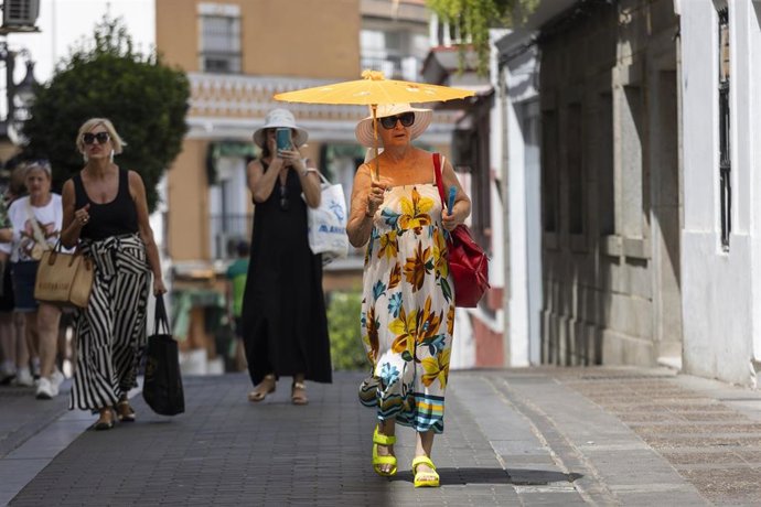 Archivo - Una mujer se protege del sol con una sombrilla, en Mérida, Badajoz, Extremadura (España).