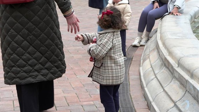 Archivo - Una niña de acogida tiende la mano a una mujer