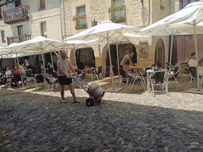 Archivo - Trabajador, sol. Calor. Pueblo. Terraza. Sombrillas. Bares.