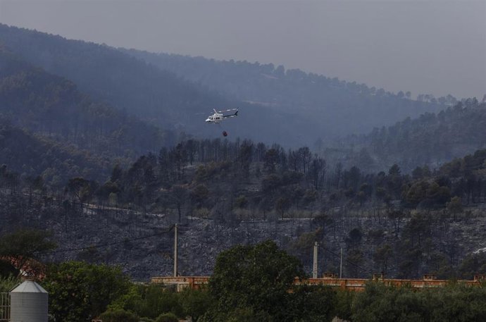 Imagen de archivo de un helicóptero trabajando en las labores de extinción del incendio forestal, a 16 de septiembre de 2026, en Tuéjar, Valencia