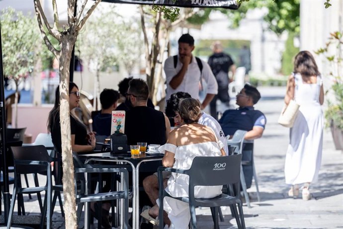 Archivo - Clientes de un bar se refrescan en la terraza