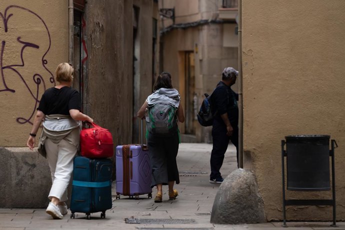Archivo - Uns turistes amb maletes al centre de Barcelona