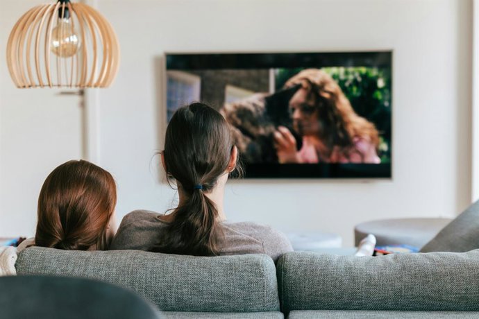 Duas pessoas no sofá assistindo à TV