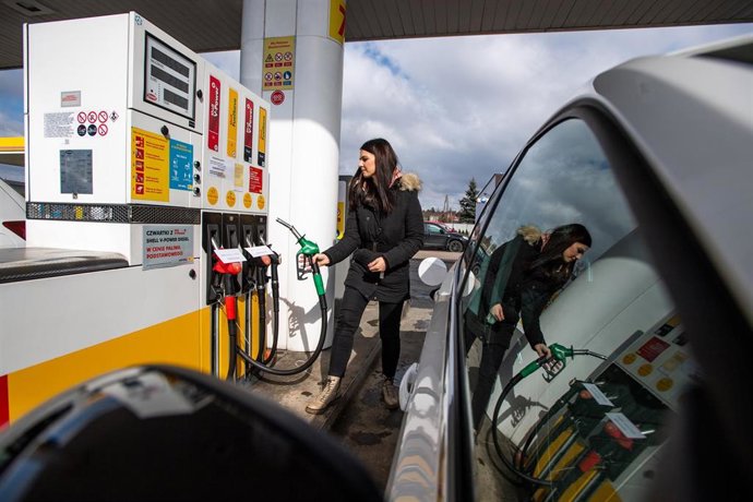 Archivo - Una checa reposta combustible en una gasolinera (archivo)