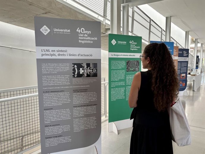 Una persona observa los desplegables de la exposición itinerante de la UIB por el 40º aniversario de la ley de normalización lingüística.