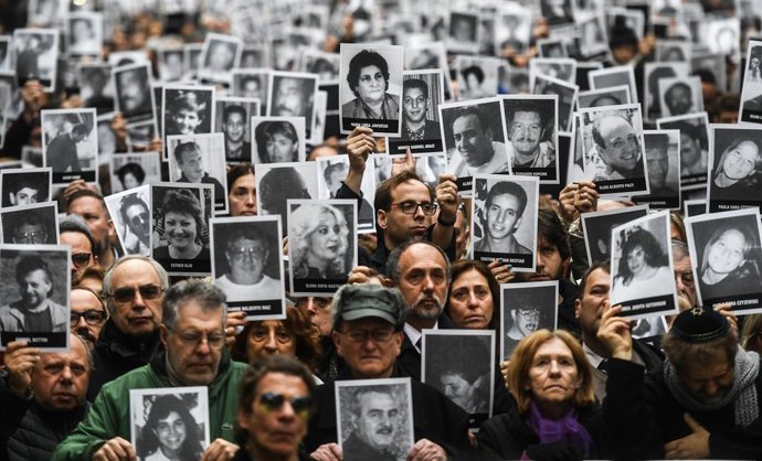 Archivo - Arquivo - ARQUIVADO - 29 de março de 2017, Argentina, Buenos Aires: Pessoas exibem fotos das vítimas em uma cerimônia de comemoração, 23 anos após o ataque terrorista à comunidade judaica AMIA em Buenos Aires, que matou 85 pessoas. Três décadas 