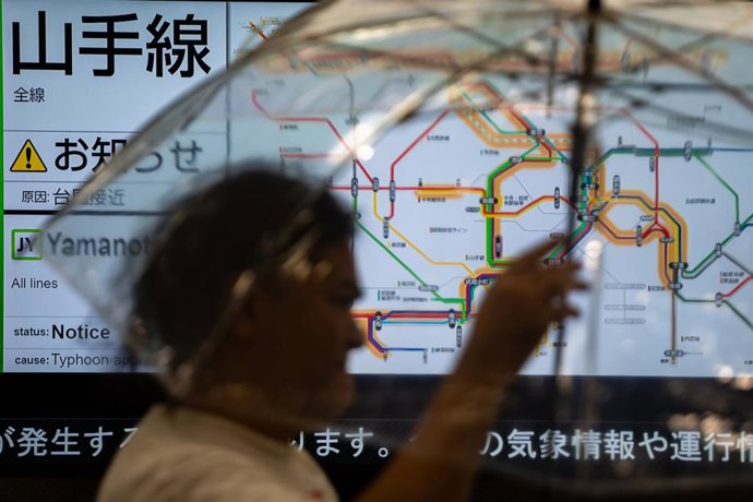 Archivo - TOKYO, Aug. 16, 2024  -- A pedestrian passes a screen displaying traffic information in Tokyo, Japan, Aug. 16, 2024.   Ampil, the seventh typhoon of the year, hit Japan on Friday, forcing cancellations of public transit services.