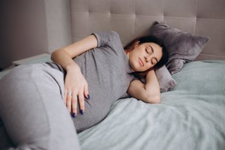 Archivo - Mujer embarazada durmiento en la cama