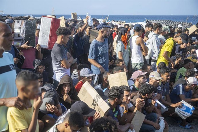 Imagen de varios migrantes en la playa de Trampolín, en Ceuta.