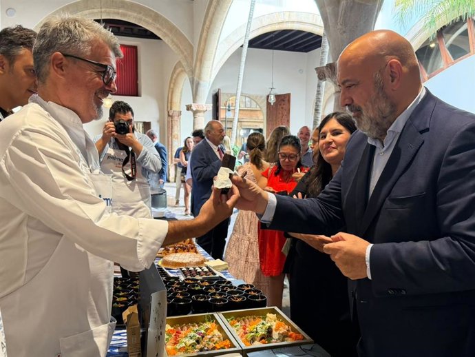 Un cocinero ofrece un producto al alcalde de Palma, Jaime Martínez, en la presentación del proyecto 'Palma capital gastronómica de las islas del Mediterráneo'.