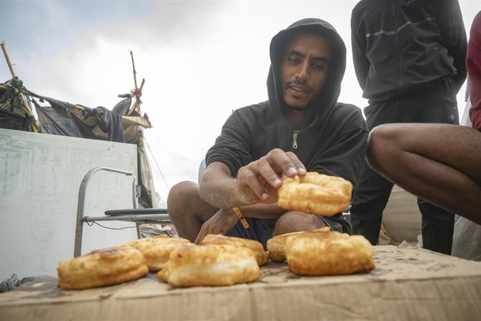 Migrante cocina, en la playa de Trampolín, a 19 de septiembre de 2026, en Ceuta (España). 