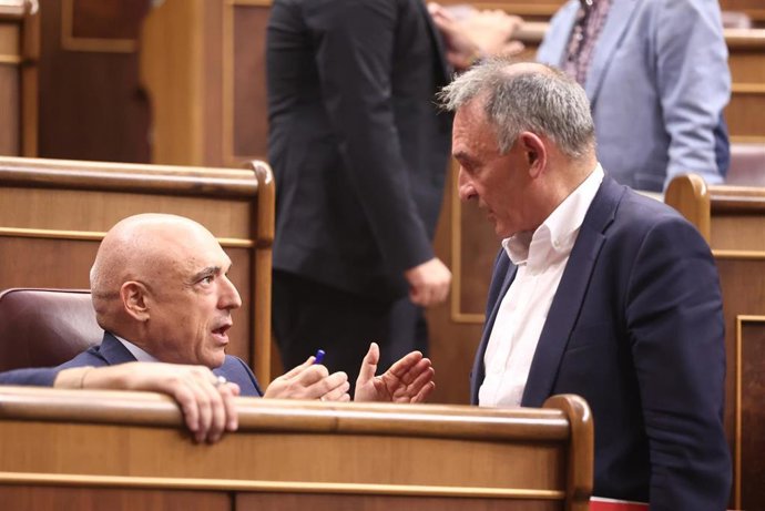 El portavoz adjunto de Sumar, Enrique Santiago, con el secretario de Estado de relaciones con las Cortes, Rafael Simancas, en una sesión plenaria 