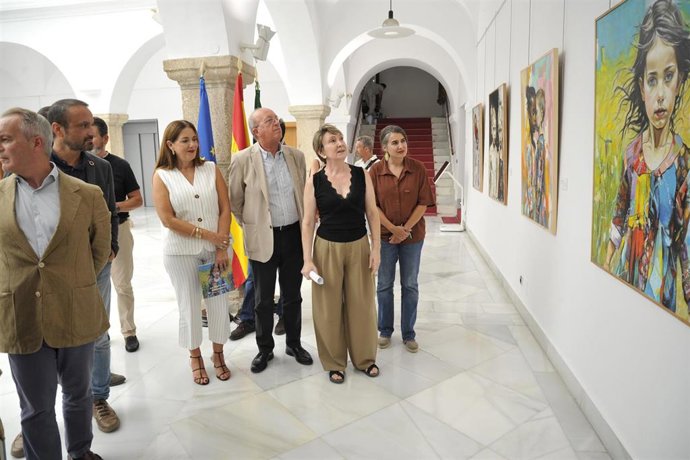 Pilar Fernández recorre las obras de su exposición en el Patio Noble de la Asamblea de Extremadura.