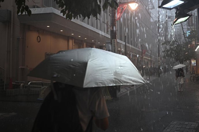 Archivo - Arquivo - 22 de agosto de 2026, Saitama, Japão: SAITAMA, JAPÃO - 22 DE AGOSTO DE 2026: Pedestres correm em direção a uma estação de trem durante uma forte chuva em Urawa, Saitama, Japão, em 22 de agosto de 2026. Uma chuva repentina encharcou pas
