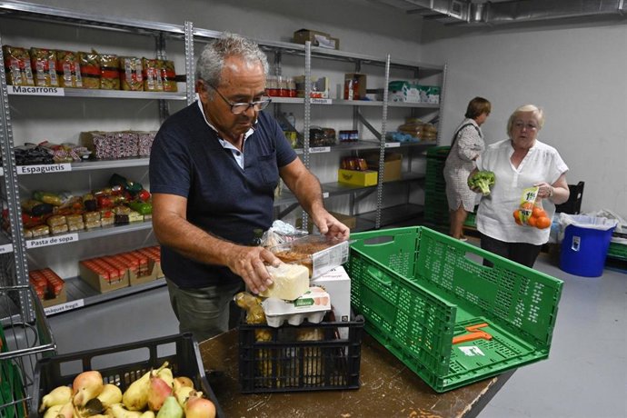 Un voluntario prepara una cesta de alimentos.