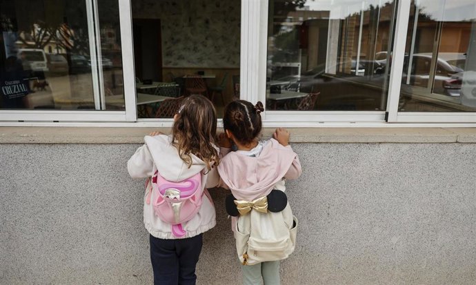 Archivo - Dos niñas observan el interior del colegio 