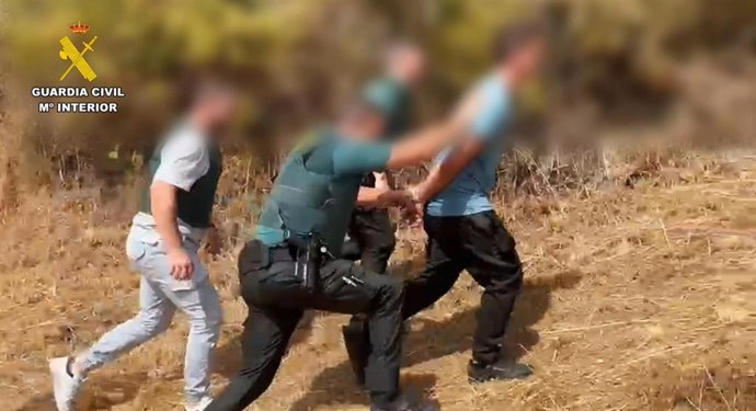 Agentes de la Guardia Civil con una persona detenida