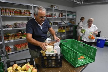 Un voluntario prepara una cesta de alimentos.