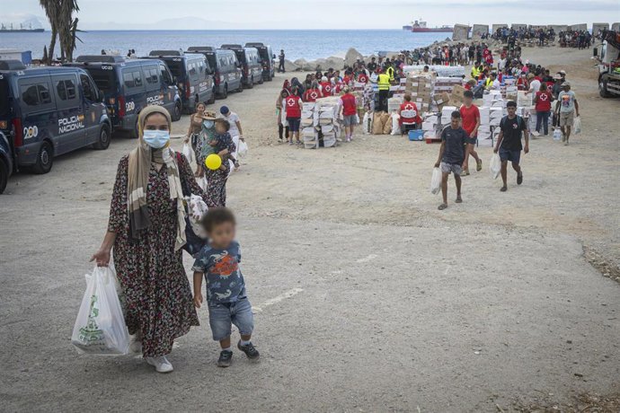 Varios migrantes recogen comida y bebida de Cruz Roja en la playa del Trampolín, a 23 de septiembre de 2026, en Ceuta (España). 