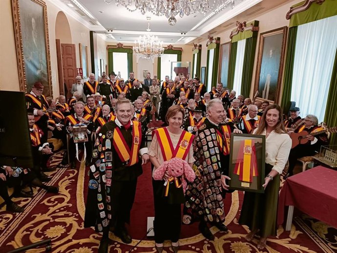 La alcaldesa de Gijón, Carmen Moriyón, recibe la beca enmarcada de Tuna España para la ciudad, en el Salón de Recepciones.