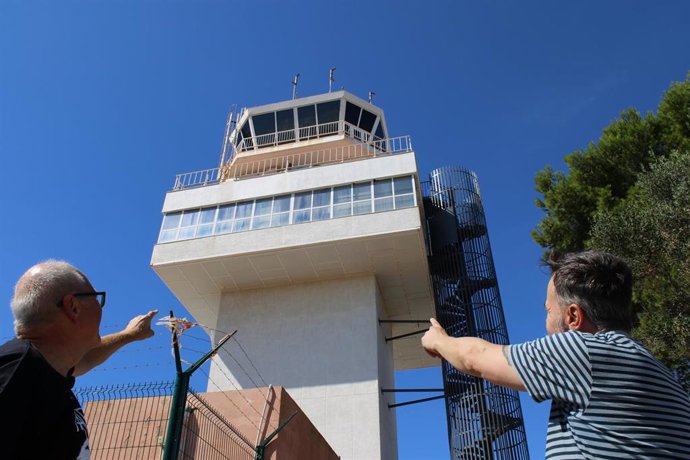 Dos hombres señalan la torre de control del aeropuerto de Menorca.