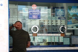 Archivo - Una persona se dispone a adquierir un boleto en una Administración de Loterias, en el centro de Sevilla. A 8 de agosto de 2024, en Sevilla (Andalucía, España).