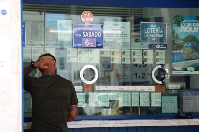 Archivo - Arquivo - Uma pessoa se prepara para comprar um bilhete em uma agência de loteria, no centro de Sevilha. Em 8 de agosto de 2024, em Sevilha (Andaluzia, Espanha).