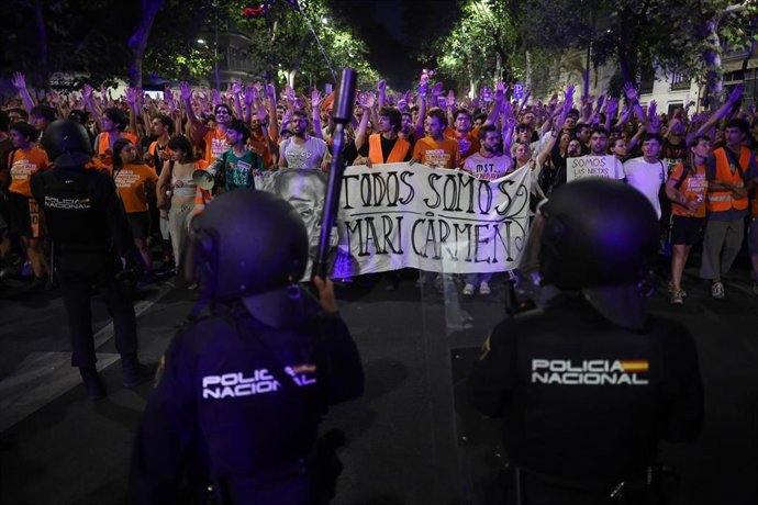 Decenas de personas frente a varios agentes de Policía Nacional durante una concentración en protesta por el desahucio de Maricarmen