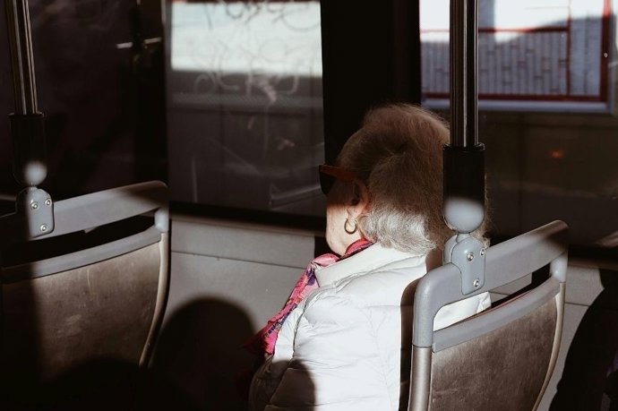 Persona mayor viajando en autobús.