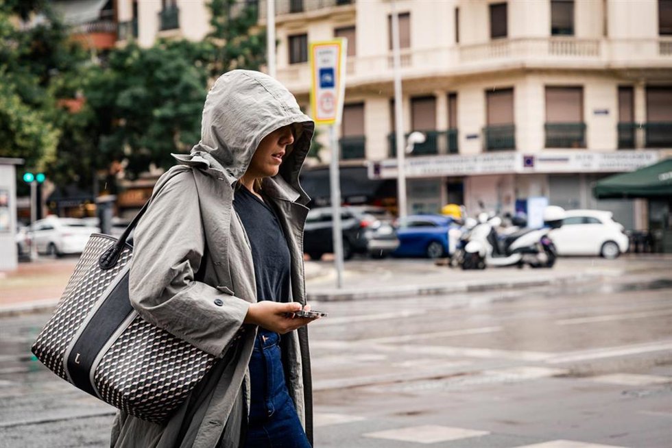 Archivo - Una mujer pasea bajo la lluvia.