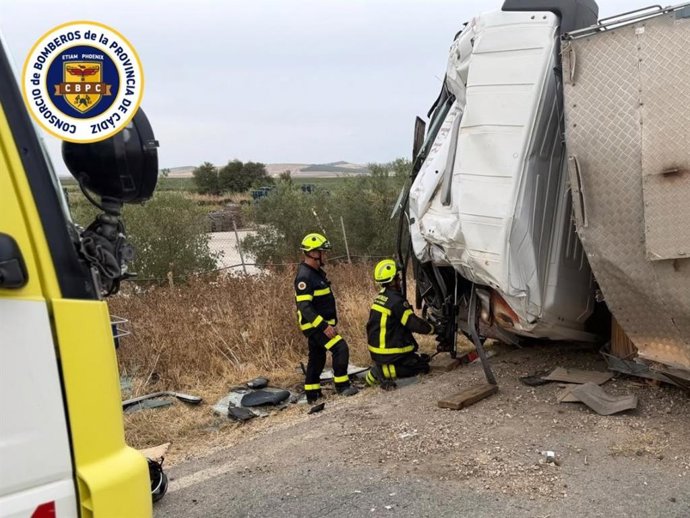 Dos bomberos actuando en la excarcelación de un camionero tras volcar su vehículo en la carretera de Jédula.