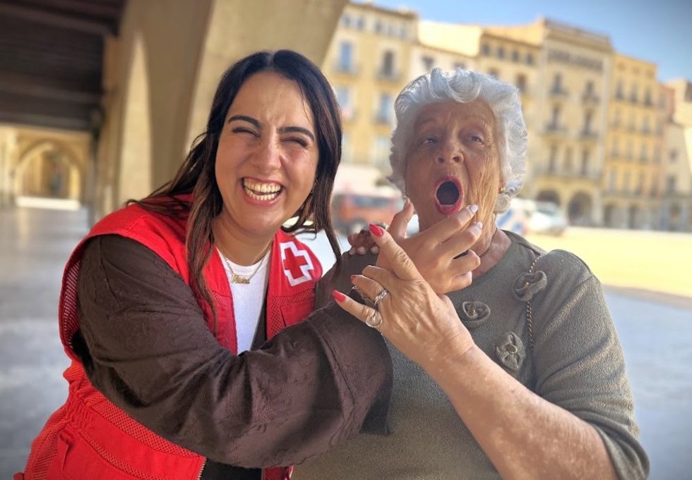 Voluntaria de la Creu Roja con una persona mayor.
