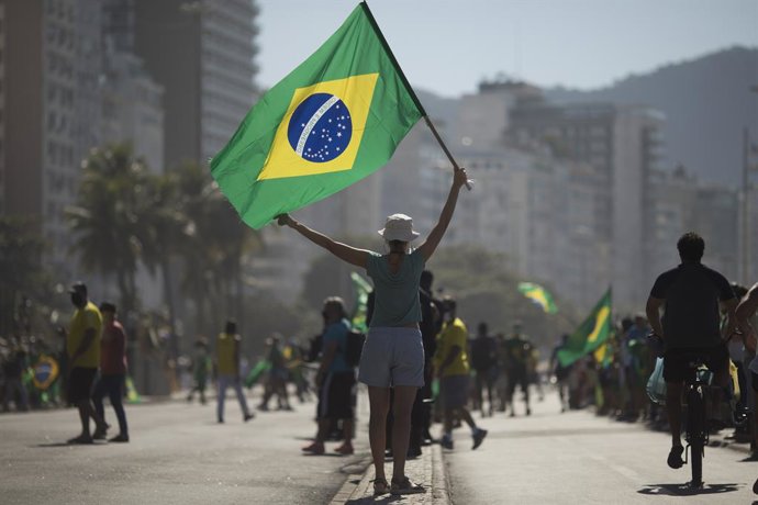 Archivo - Una seguidora de Bolsonaro con una bandera de Brasil.