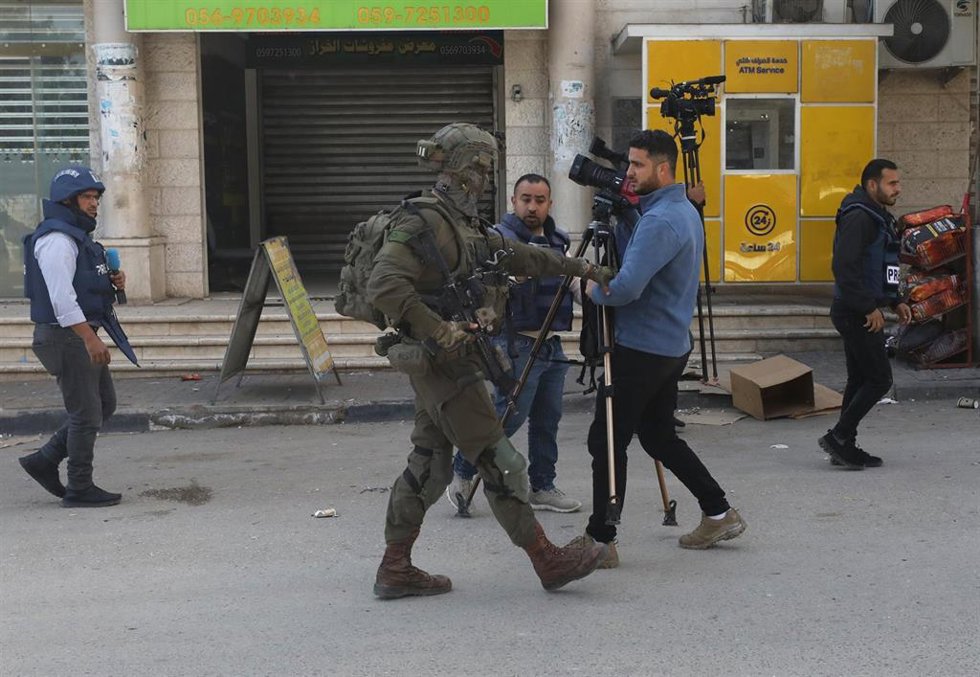 Archivo - Un soldado israelí trata de impedir la cobertura de un periodista palestino en Tubas, Cisjordania 