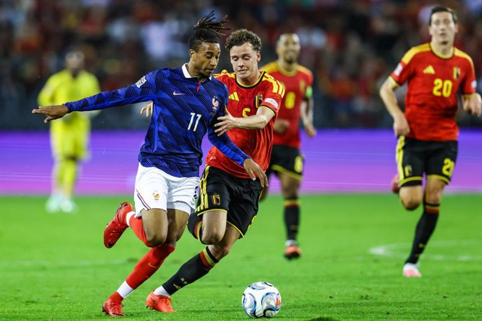 O francês Michael Olise e o belga Maxim De Cuyper disputam a bola durante uma partida de futebol entre a seleção belga, os Red Devils, e a França, na segunda-feira, 28 de setembro de 2026, em Bruxelas, na segunda partida da fase de grupos da Liga das Naçõ