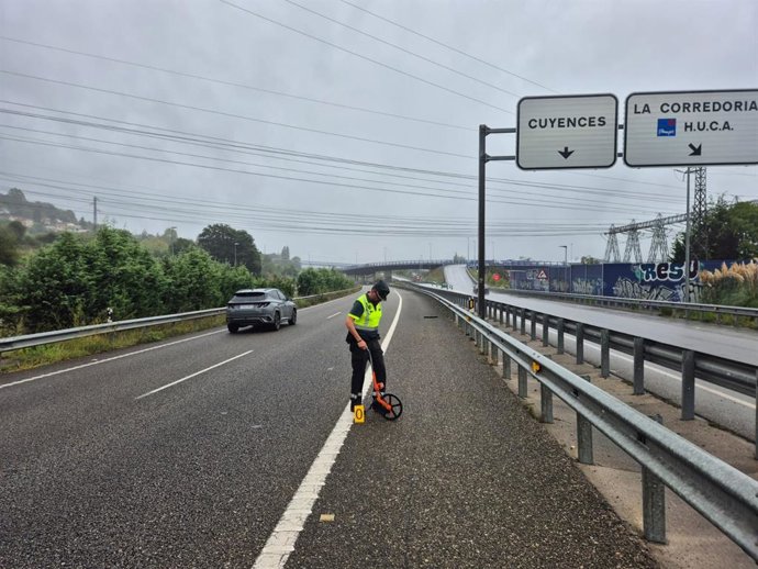 Un agente de la Guardia Civil investiga el lugar del accidente en la AS-II