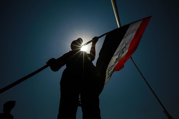 Archivo - Un hombre con una bandera de Irak en la capital, Bagdad
