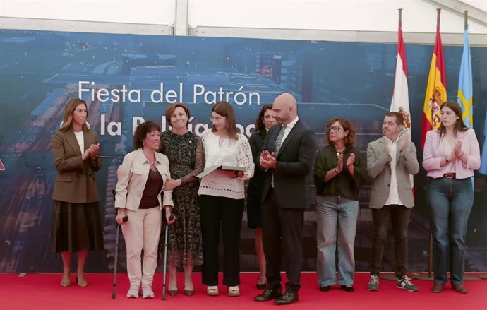 La alcaldesa de Gijón, Carmen Moriyón,  hace entrega, a la viuda e hija de Juan Carlos Francisco Casado, de la distinción de la Policía Local a título póstumo durante el acto de celebración de la Policía Local, con motivo de su patrón, San Miguel.