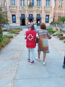Una voluntaria de Cruz Roja acompañada a una asistentes a las jornadas de promoción a la salud.