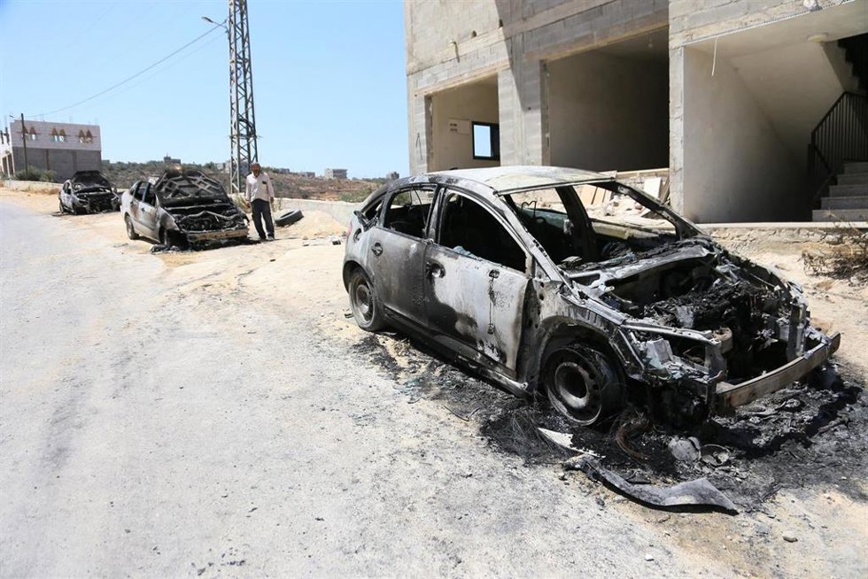Archivo - Palestinos inspeccionan vehículos calcinados tras un ataque de colonos judíos contra viviendas palestinas en Jalud, Cisjordania